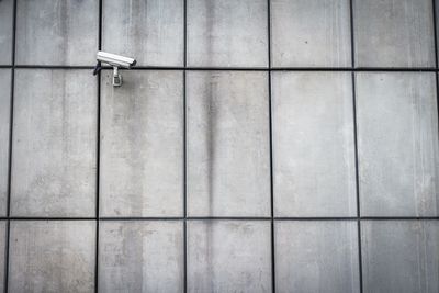 Low angle view of security camera on gray wall