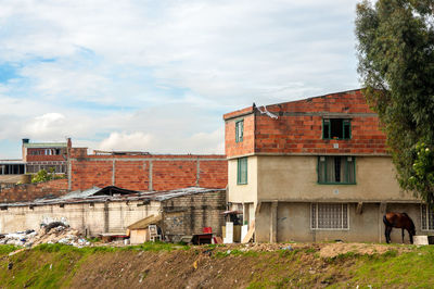 Houses against cloudy sky