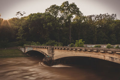 Arch bridge over river during heavy flood 