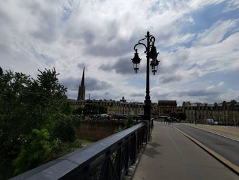 Street light by road against sky in city