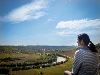 Woman standing on landscape against sky