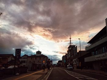 View of city street against cloudy sky