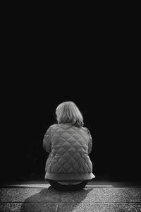 Rear view of man against black background