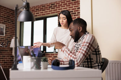 Side view of woman using laptop while sitting at home