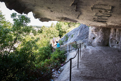 Staircase by rock formation against trees