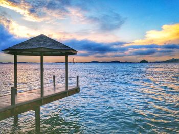 Lifeguard hut on beach against sky during sunset