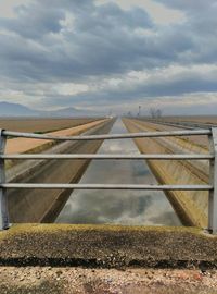 Railroad track against cloudy sky