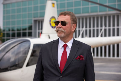 Portrait of businessman wearing sunglasses standing outdoors