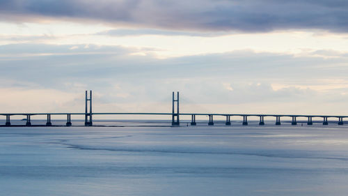 View of suspension bridge against cloudy sky