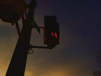 Low angle view of illuminated light against sky at sunset