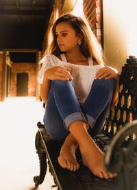 Young woman looking down while sitting at home