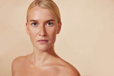 Portrait of young woman against pink background