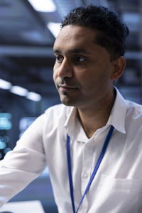 Portrait of young man standing in office