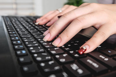 Cropped hand of woman using laptop