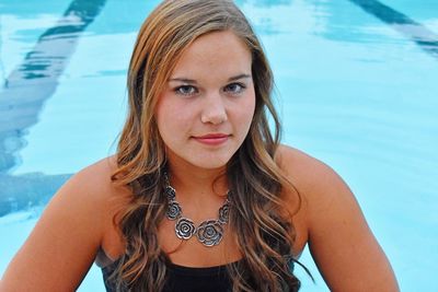 Portrait of young woman against swimming pool