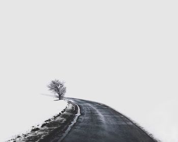 Snow on road against clear sky