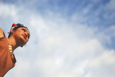 Low angle view of woman standing against clear sky