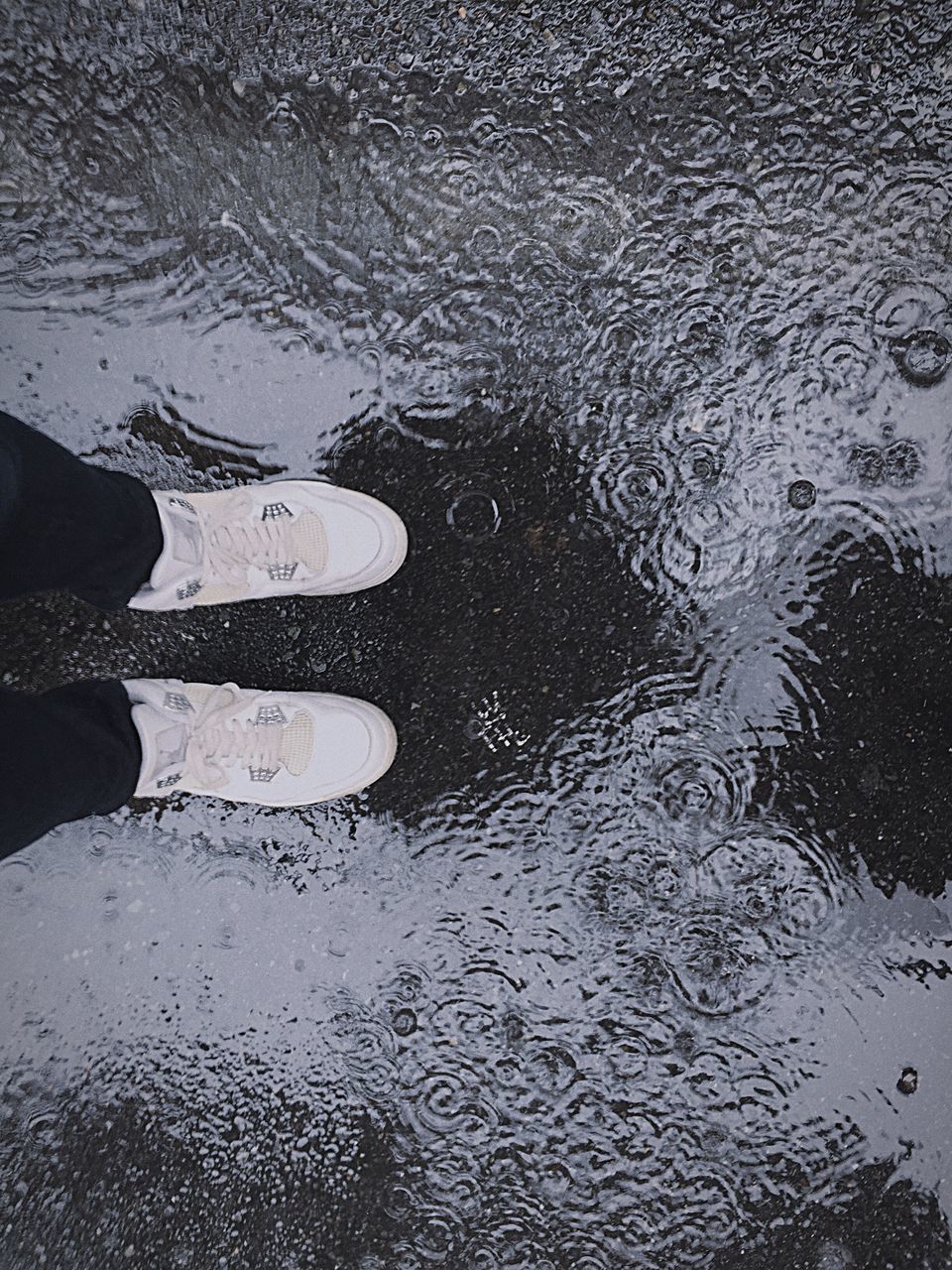 LOW SECTION OF PERSON STANDING ON PUDDLE