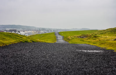 Road amidst land against sky