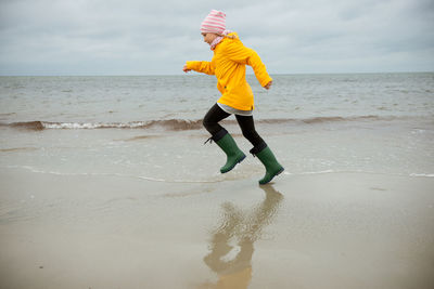 Full length of girl running at beach