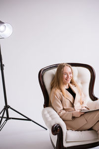 High angle view of young woman sitting against white background