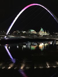 View of bridge over river at night