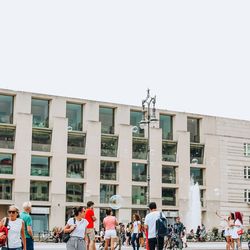 People on street against buildings in city