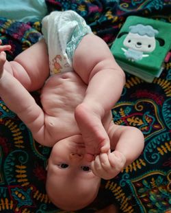 High angle view of baby lying on bed