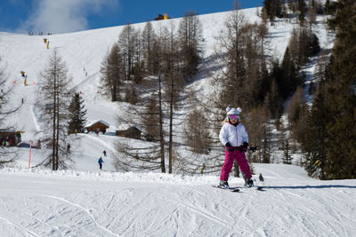 Rear view of people skiing on snow covered mountain