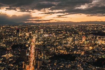 High angle view of illuminated cityscape against sky at dusk