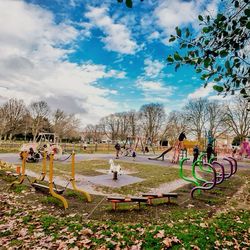 Trees on field against cloudy sky