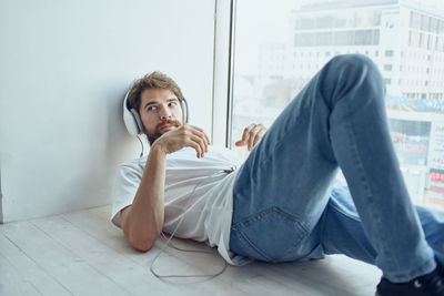 Young man listening music at home