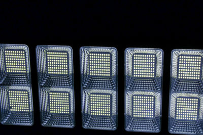 Full frame shot of illuminated lighting equipment against black background