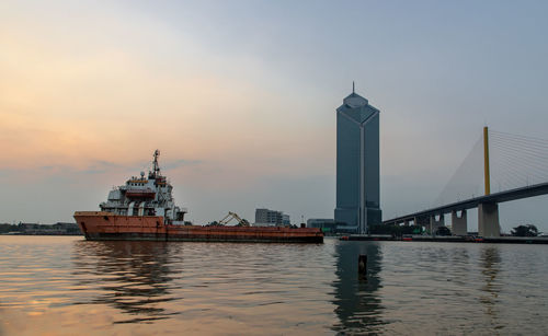 View of ship in city at sunset