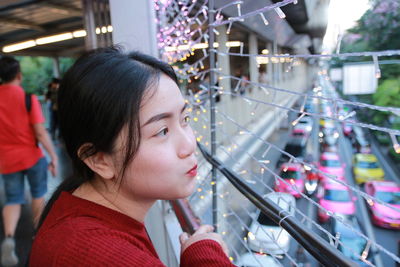 High angle close-up of woman looking away while standing by railing