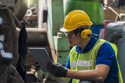 Technicians are customizing the operation of industrial machines with a tablet.