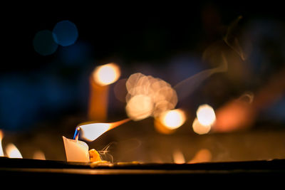 Close-up of lit candles against blurred background