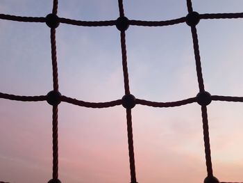 Full frame shot of metal fence against sky during sunset