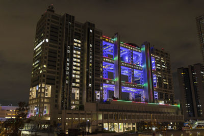 Low angle view of illuminated buildings against sky at night
