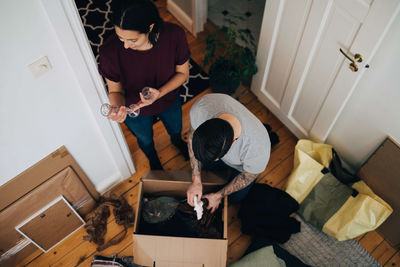 High angle view of couple unpacking box at home