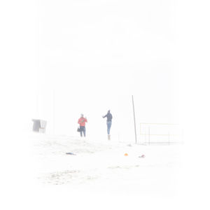 People on snow against clear sky