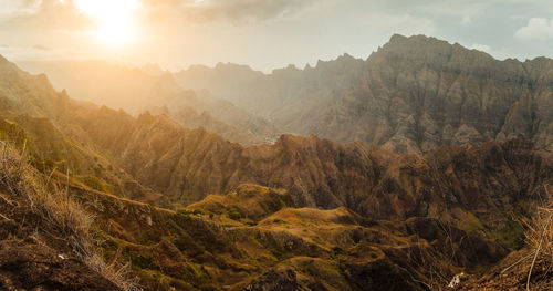 Scenic view of land and mountains against sky