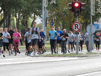 Group of people running on road in city