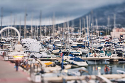 High angle view of sailboats moored in harbor by buildings in city