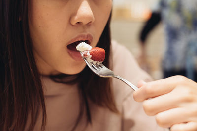 Midsection of woman eating strawberry