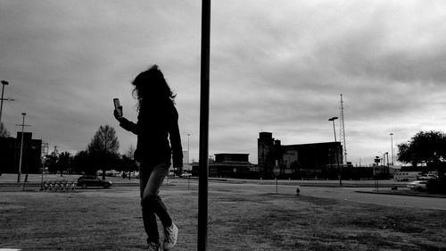 Side view of silhouette man standing on street against sky