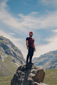 Rear view of man standing on mountain against sky
