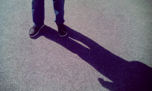 Low section of man standing on road