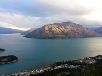 Scenic view of sea and mountains against sky
