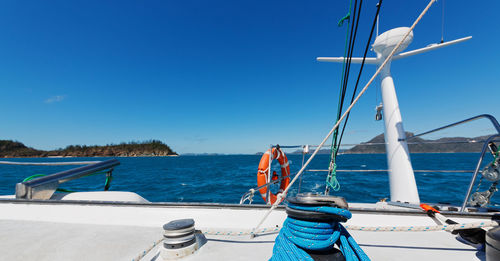 Sailboats in sea against clear blue sky